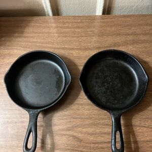 2 black small size cast iron pans